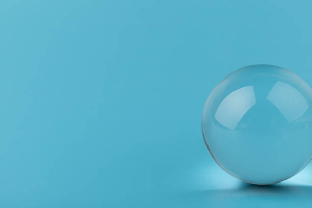 istock Crystal glass ball sphere transparent on blue background. 1355606399