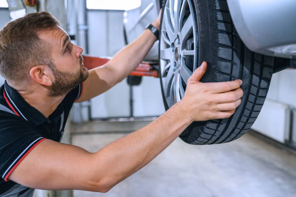 istock Car mechanic is changing tire 1355608832