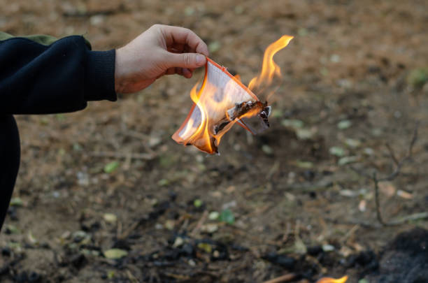 istock A man burns a sheet of paper with handwritten text. 1355608846