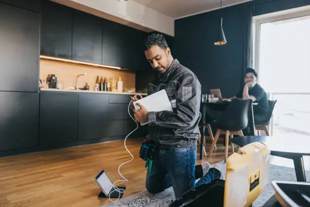 Indian technician installing wifi router at customers house.