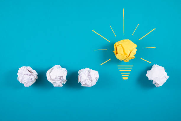 istock Crumpled Paper Light Bulb over Blue Background 1355613572