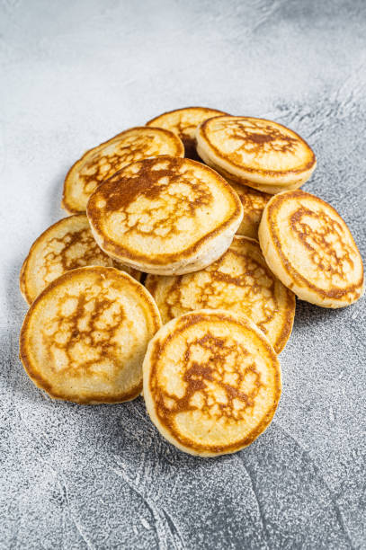 istock Stack of buttered pancakes on a kitchen table. White background. Top View 1355613997