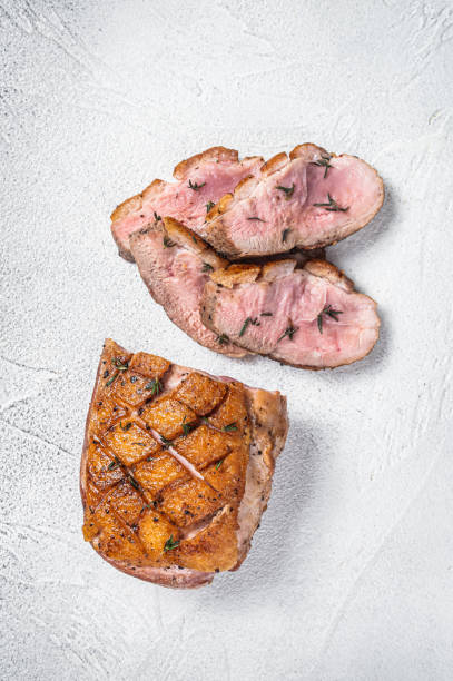 istock Roasted Sliced Duck breast fiilet steak. White background. Top view 1355616357