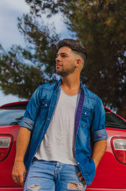istock A handsome young man leaning on the back of his car looking aside 1355616507