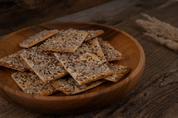 istock cereal cracker, rectangular bread or cookies with seeds and different seeds on a wooden background close-up 1355618371
