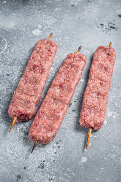 istock Raw Turkish Adana shish kebab on butcher table. Gray background. top view 1355618607