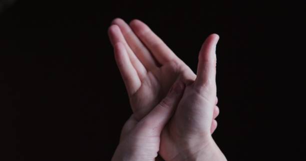 istock Human hands are using hand cream. Personal point of view against black background 1355618823