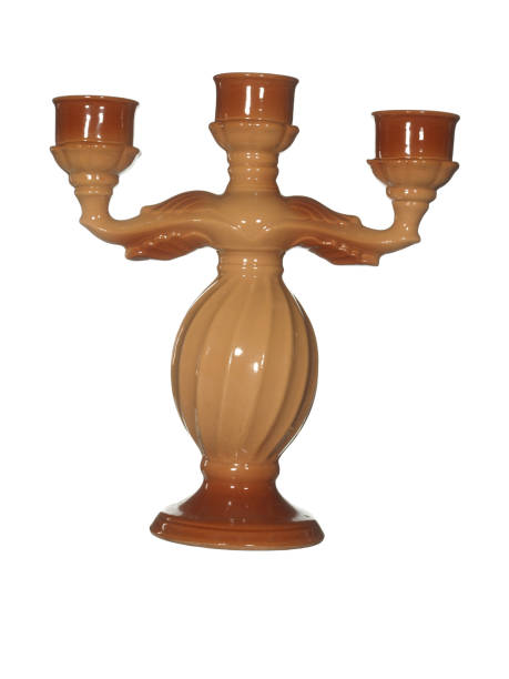istock Ceramic candelabrum for three candles in brown color isolated on white background. 1355619912