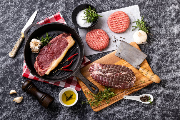 istock Different cuts of raw meat on black background 1355620232