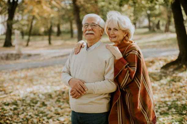 istock Senior couple embracing in autumn park 1355621938