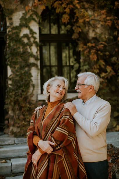 istock Senior couple embracing in autumn park 1355621951