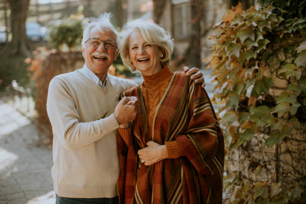istock Senior couple embracing in autumn park 1355621956