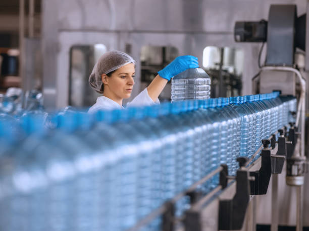 istock Technologist in bottling factory checking water bottles before shipment. 1355622807
