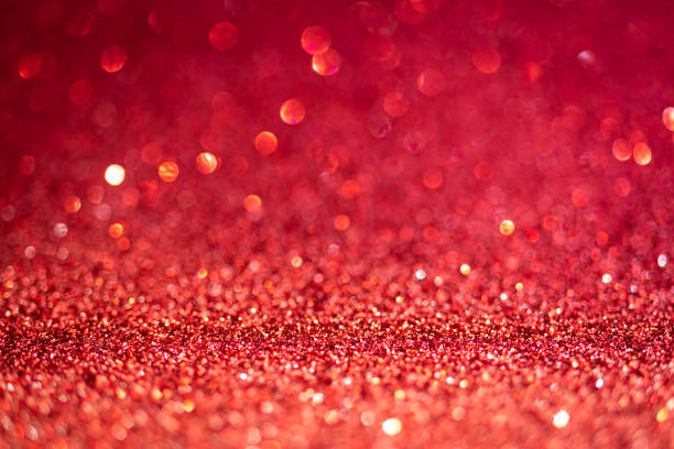 istock Red shiny glitter texture. Selective focus. Glowing surface, sparkle lights and bokeh effects. Christmas and festive background 1355626799