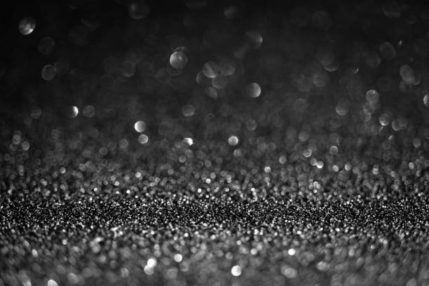 istock Black shiny glitter texture. Selective focus. Glowing surface, sparkle lights and bokeh effects. Christmas and festive background 1355626848