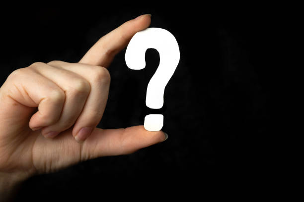 istock Question mark sign in hand. Question icon, symbol on a black background 1355626918