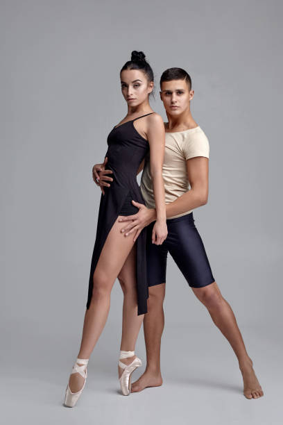 회색 스튜디오 배경에 대해 포즈를 취하고있는 두 운동 현대 발레 댄서 - pair sensuality couple heterosexual couple 뉴스 사진 이미지