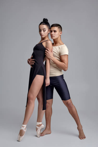 due atletici ballerini moderni sono in posa su uno sfondo grigio dello studio - pair sensuality couple heterosexual couple foto e immagini stock
