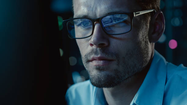 istock At Night Portrait of Handsome Startup Digital Entrepreneur Working on Computer, Line of Code Reflecting in Glasses. Developer Working on Innovative e-Commerce App using AI Algorithm Big Data. Blue 1355632581