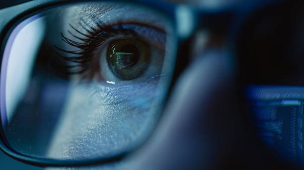 super close-up su female eye, ingegnere del software che lavora al computer, programmazione che riflette negli occhiali. sviluppatore che lavora su un'applicazione di e-commerce innovativa utilizzando machine learning, ai, big data - spy foto e immagini stock