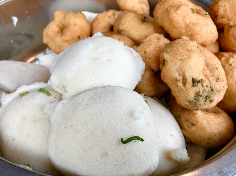 Soft and fluffy fresh Idlis (white) and  daal Vadas (brownish) -  very popular batter-based snacks from South Indian cuisine.