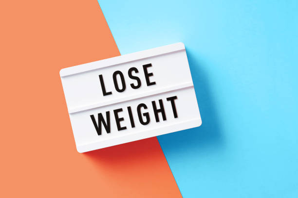 istock Lose Weight Written White Lightbox Sitting On Pink And Blue Background 1355635357