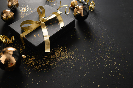 Still life photography of an abstract holiday / party  background. Shiny Christmas decoration on gold and blue defocused lights. Golden shiny glitter, lens flares, and defocused blue lights. Native image size: 7952x5304