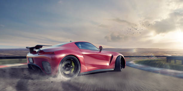 Generic Red Sports Car Drifting Around Racetrack Corner At Speed A generic red sports car moving at high speed around the corner of a racetrack. The vehicle is drifting around the corner, with smoke coming from its spinning rear tires. The racetrack is fictional in a remote location with distant hills. It is sunset/sunrise under a cloudy sky. aerodynamic photos stock pictures, royalty-free photos & images