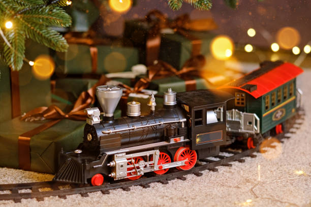 Toy train under Christmas tree Toy train under Christmas tree. Home party decoration miniature train stock pictures, royalty-free photos & images