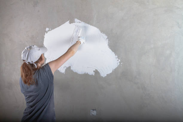 istock A female construction worker puts a concrete wall in the house with a spatula with white putty 1355638690