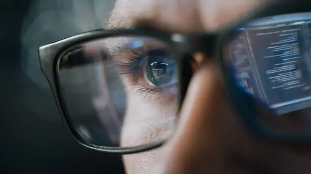 Photo of Close-up Portrait of Software Engineer Working on Computer, Line of Code Reflecting in Glasses. Developer Working on Innovative e-Commerce Application using Machine Learning, AI Algorithm, Big Data
