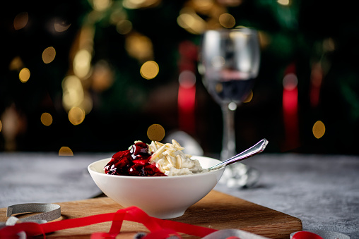 Close up picture of a traditional danish rice pudding or risalamande dessert served at Christmas time in Denmark and other parts of Scandinavia. It is traditionally served with a rich cherry sauce and chopped almonds. Usually there is a small silver coin hidden in the dessert that one lucky child will find.