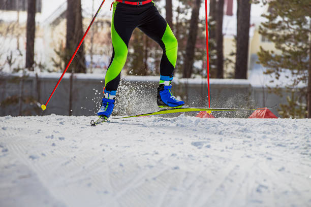 クロスカントリースキーで上り坂を走るスキーヤーアスリート - mens cross country skiing ストックフォトと画像