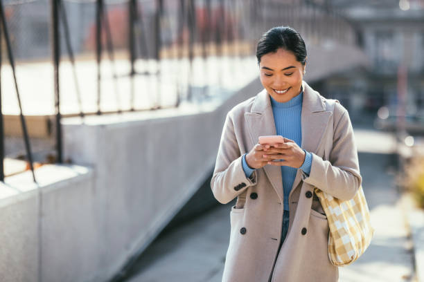 Happy Woman Using Mobile Phone Outdoors