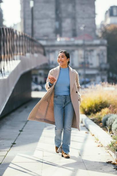 istock Beautiful Woman Using Mobile Phone Outdoors 1355642311