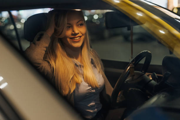 istock Young beautiful female driver looking at herself in rearview mirror 1355643594