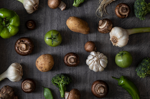 Various green and vegetables on dark wooden table
