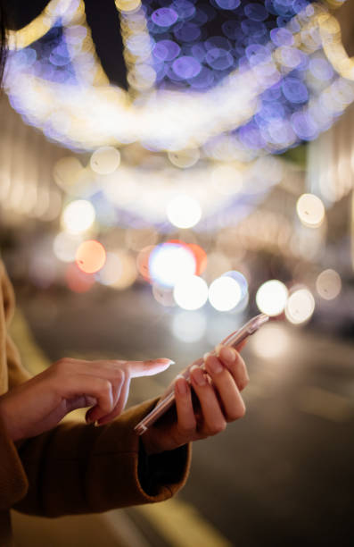 istock Close-up hand using phone in night time on street 1355645247