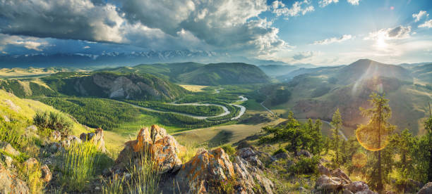 Above a picturesque mountain valley with a river, evening light
