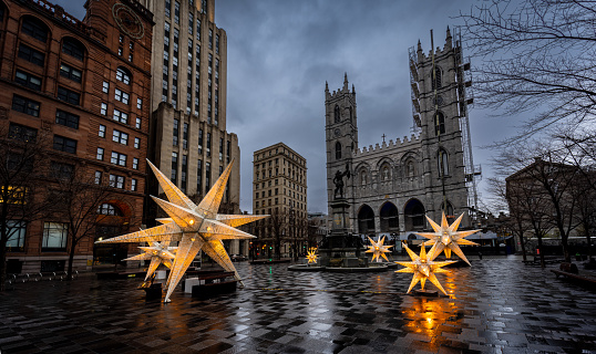 the Place d'Armes in Montreal, in preparation for the month of December with Christmas decorations, Notre Dame Basilica in the background, The Monument à Maisonneuve is a work by Louis-Philippe Hébert in memory of Maisonneuve, founder of Montreal, installed in 1895 in the center of Place d'Armes in Old Montreal.
