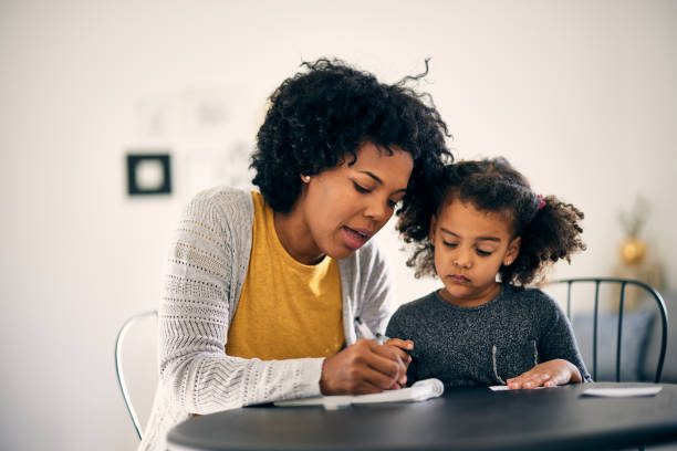 istock Caring african-american mother, educating her daughter 1355649580