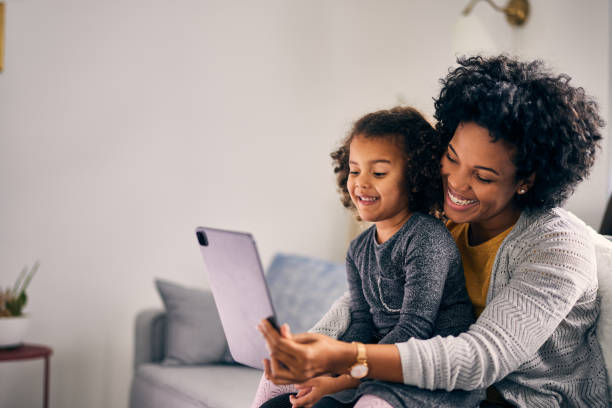 istock Smiling adult woman, using a tablet to make self portrait 1355649609