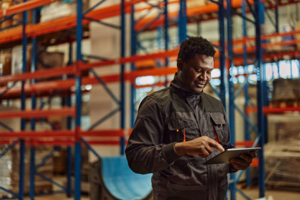 istock Ambitious factory worker, coordinating with his colleague. 1355649723