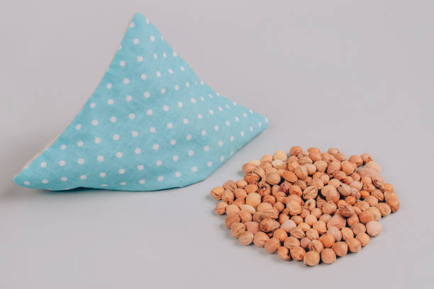 blaues kirschkernkissen, mit kirschkern gefülltes kissen mit kirschkernen auf grauem hintergrund. natürliche wärme oder kühlpack. alternativmedizin und therapie, grubensack für spa-massage, selektiver fokus - cool-pack stock-fotos und bilder