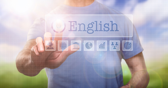 A man in a t-shirt outside selecting a English word concept on a computerised display