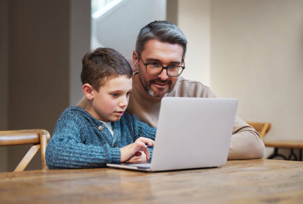 istock Shot of a father and son team using a laptop to complete school work 1355653064