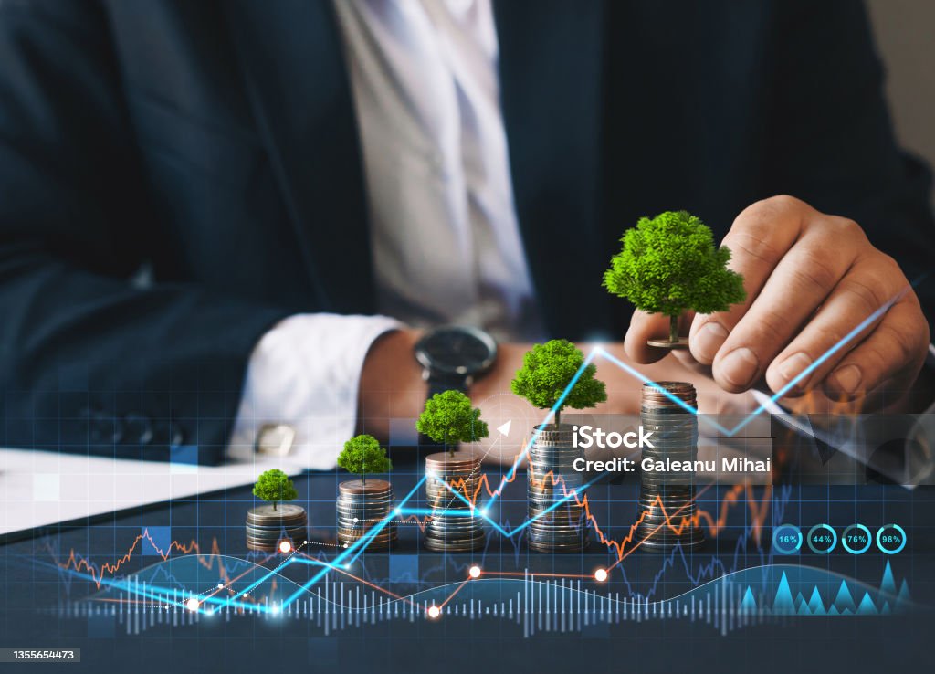 Eco business investment. Green business growth. Businessman holding coin with tree growing on money coin stack. Finance sustainable development.Concept of pass and increase of renewable energy. Eco business investment. Green business growth. Businessman holding coin with tree growing on money coin stack. Finance sustainable development.Concept of pass and increase of renewable energy Sustainable Resources Stock Photo