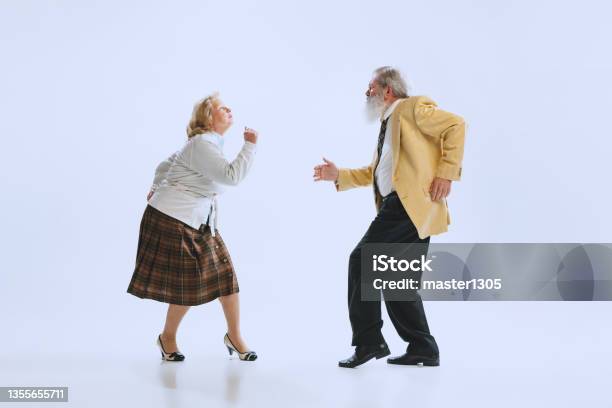 Dynamic Portrait Of Retro Style Dancers Senior Man And Woman In Vintage Attire Dancing Swing Isolated On White Background Stock Photo - Download Image Now