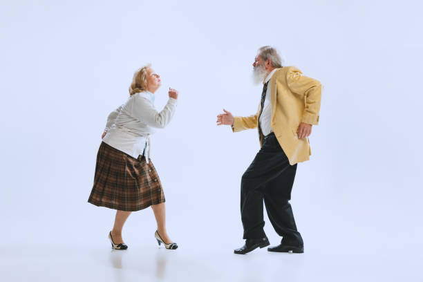 динамичный портрет танцоров в стиле ретро, пожилых мужчин и женщин в винтажных нарядах, танцующих свинг на белом фоне - retro revival couple men elegance стоковые фото и изображения