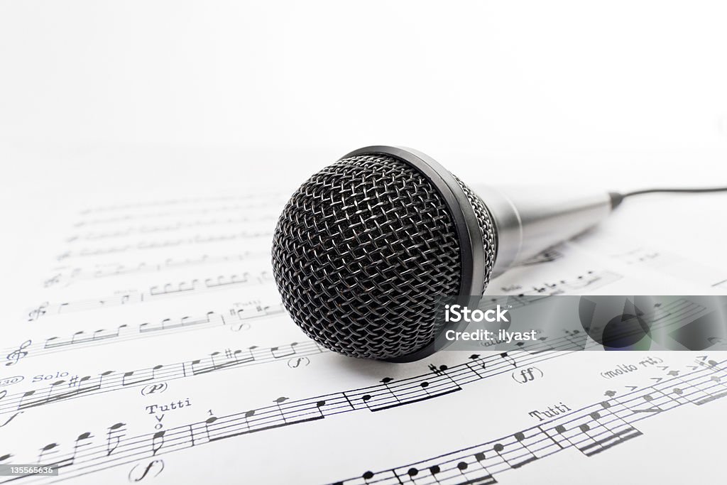 Microphone on Sheet Music Close-up of black microphone on page of sheet music Black Color Stock Photo